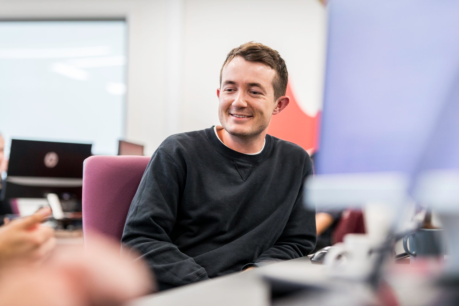 Man smiling in UK office Andrew Thomas Avidly