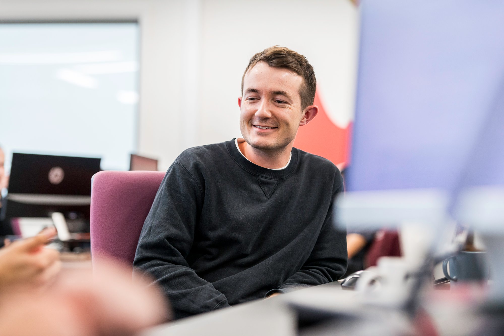 Man smiling in office Andrew Thomas Avidly