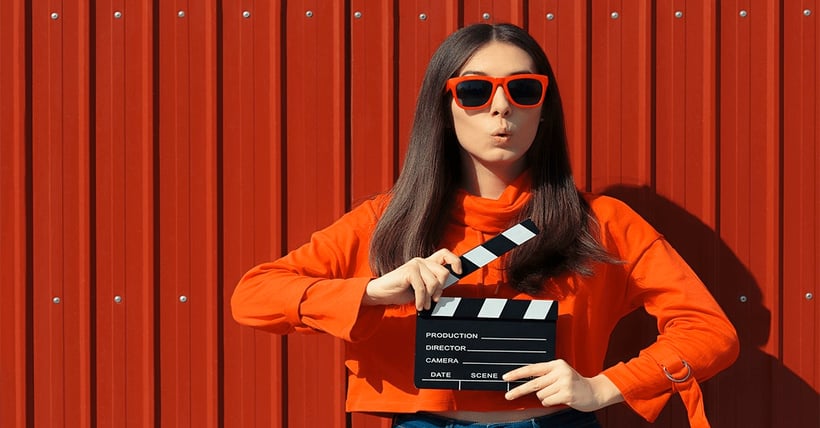woman-holding-movie-clipper-board-red-glasses